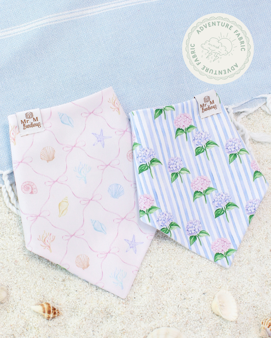 Two dog bandanas on a sandy background.
